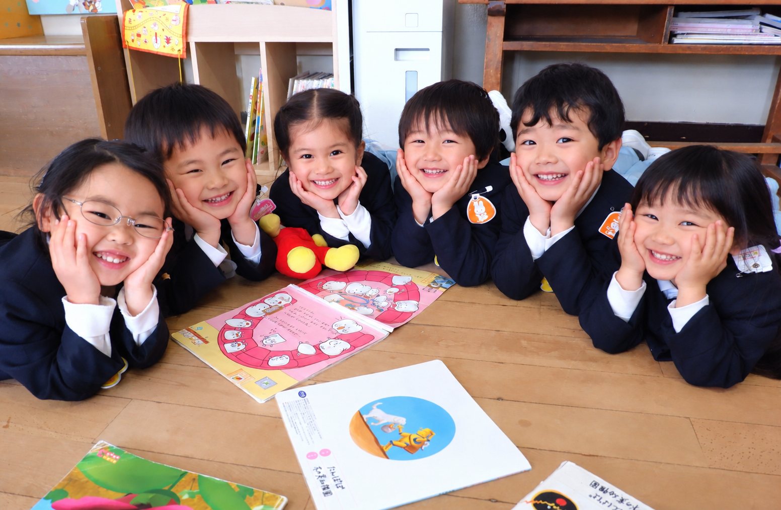 保育室で絵本を囲む子どもたち