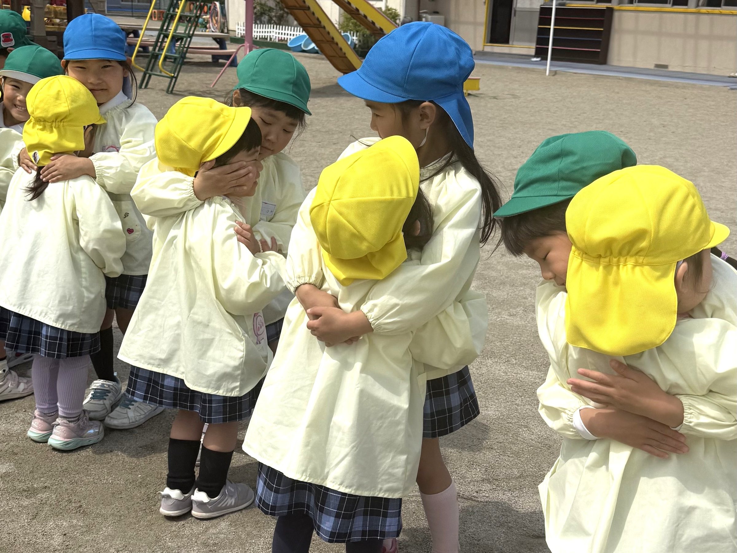 園庭で抱き合う子どもたち